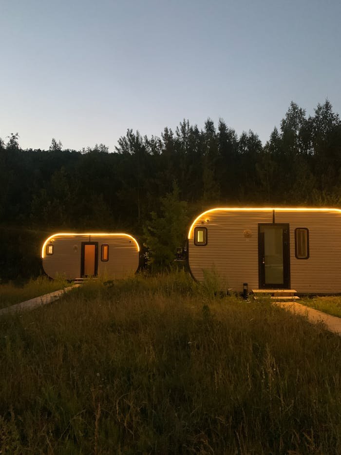 Scenic evening view of glowing trailers surrounded by nature at twilight.